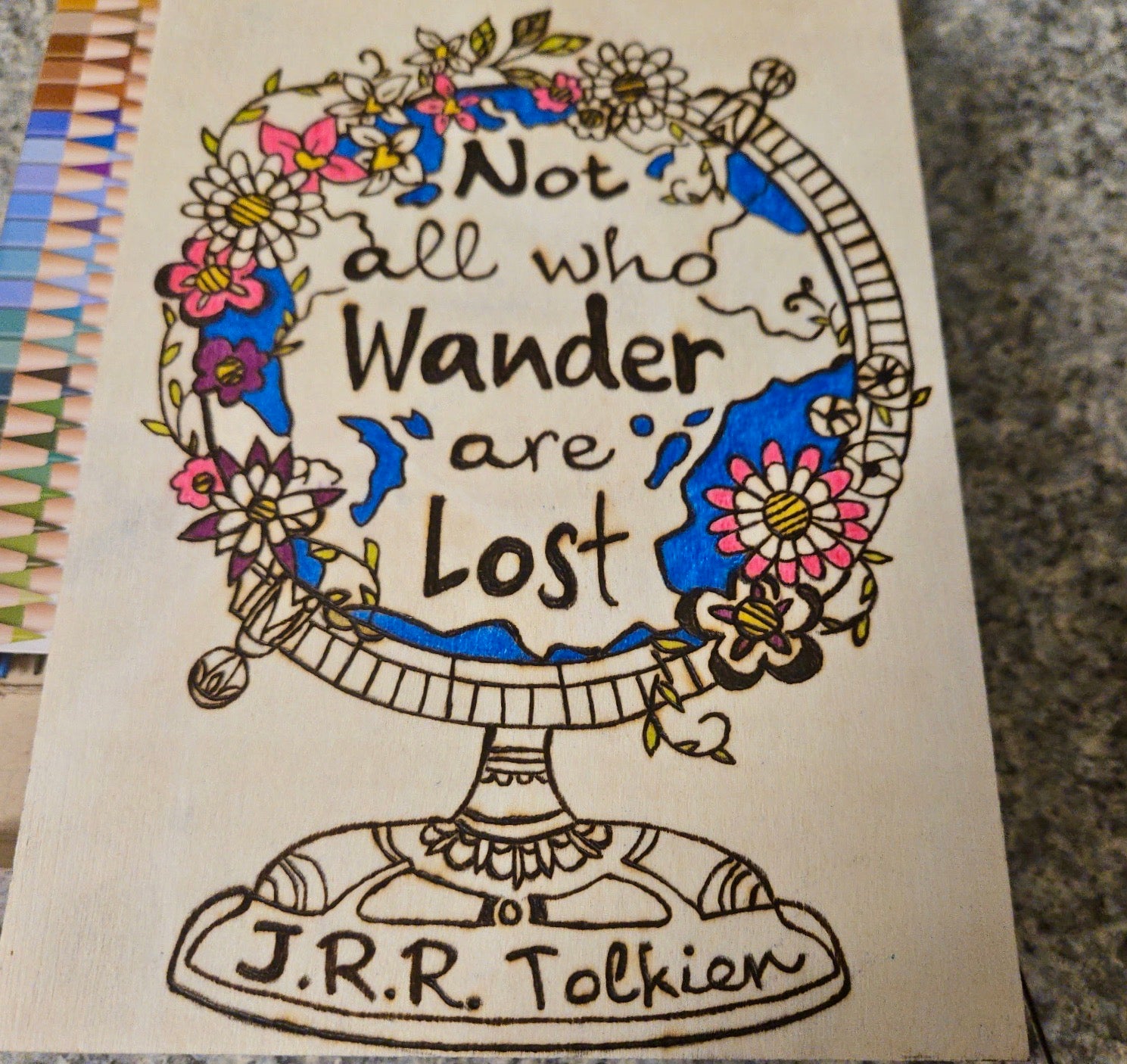 Hand burned and colored wood wall art featuring Tolkien globe illustration with Not All Who Wander Are Lost quote