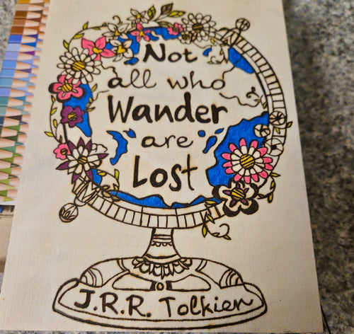 Hand burned and colored wood wall art featuring Tolkien globe illustration with Not All Who Wander Are Lost quote