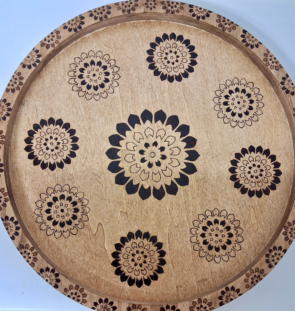 Close-up of hand wood-burned mandala floral pattern on round wood serving tray